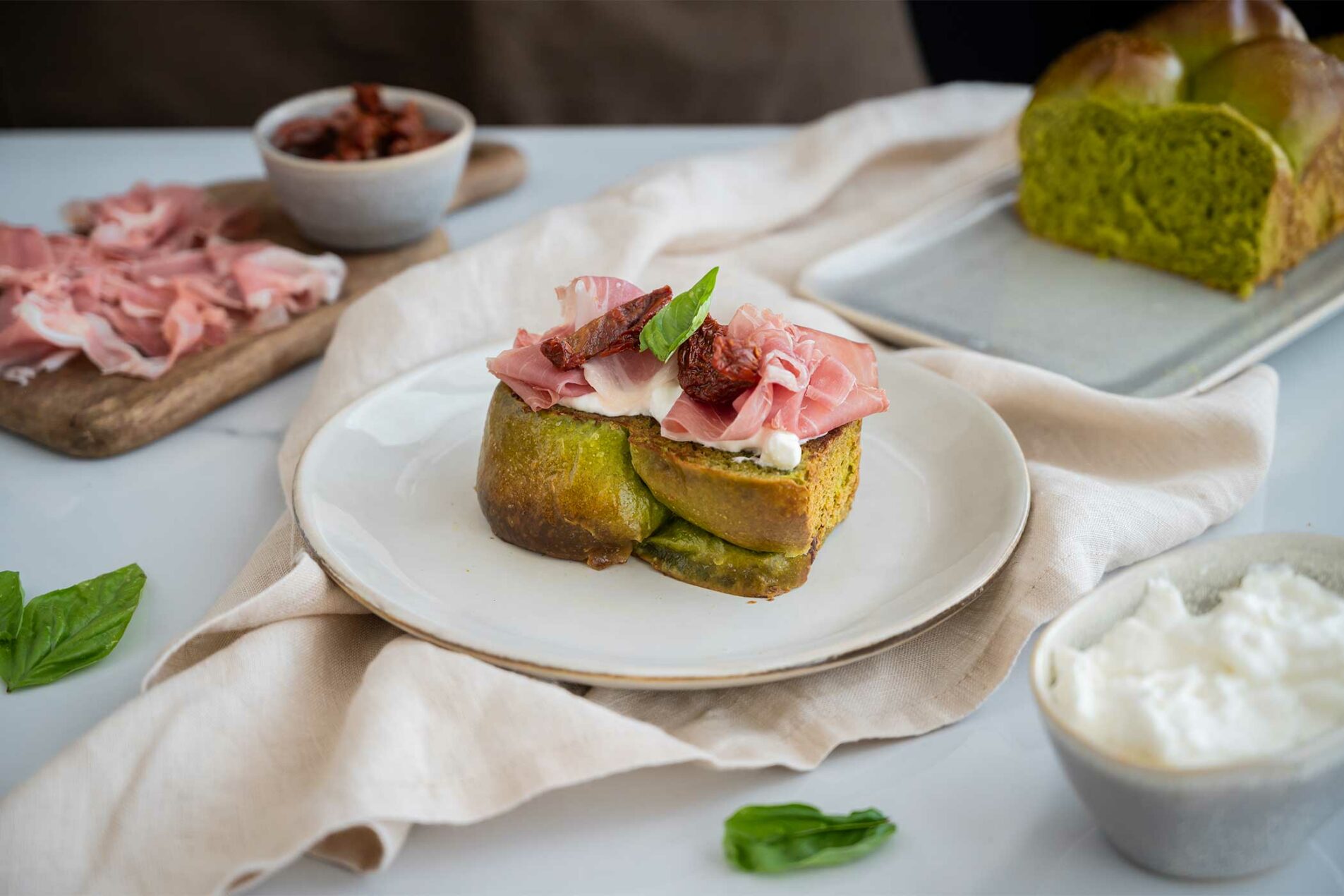 Pan brioche agli spinaci con stracciatella, Prosciutto di San Daniele, pomodori secchi e basilico