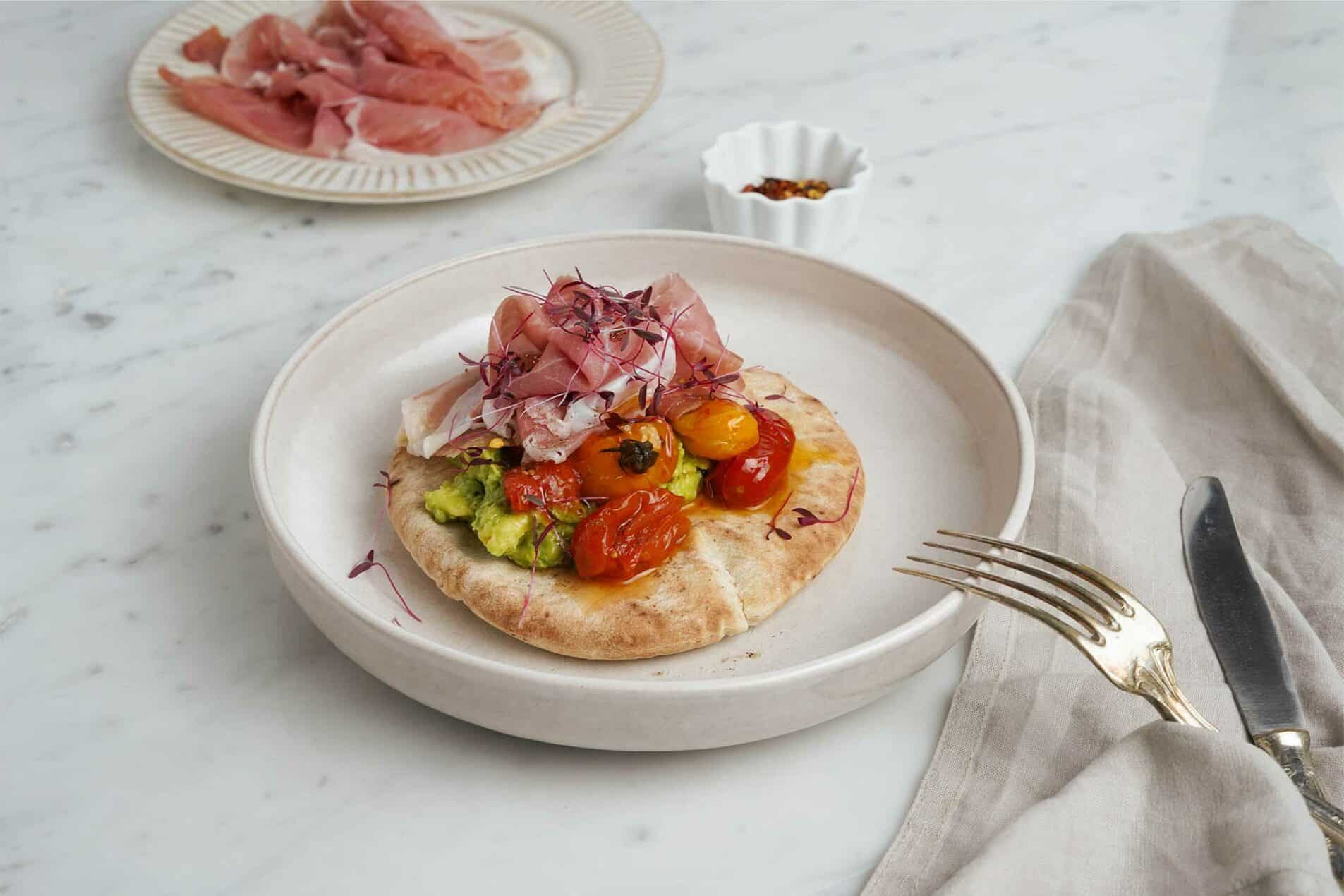 Pita gefüllt mit San Daniele Schinken, Guacamole und gerösteten Kirschtomaten