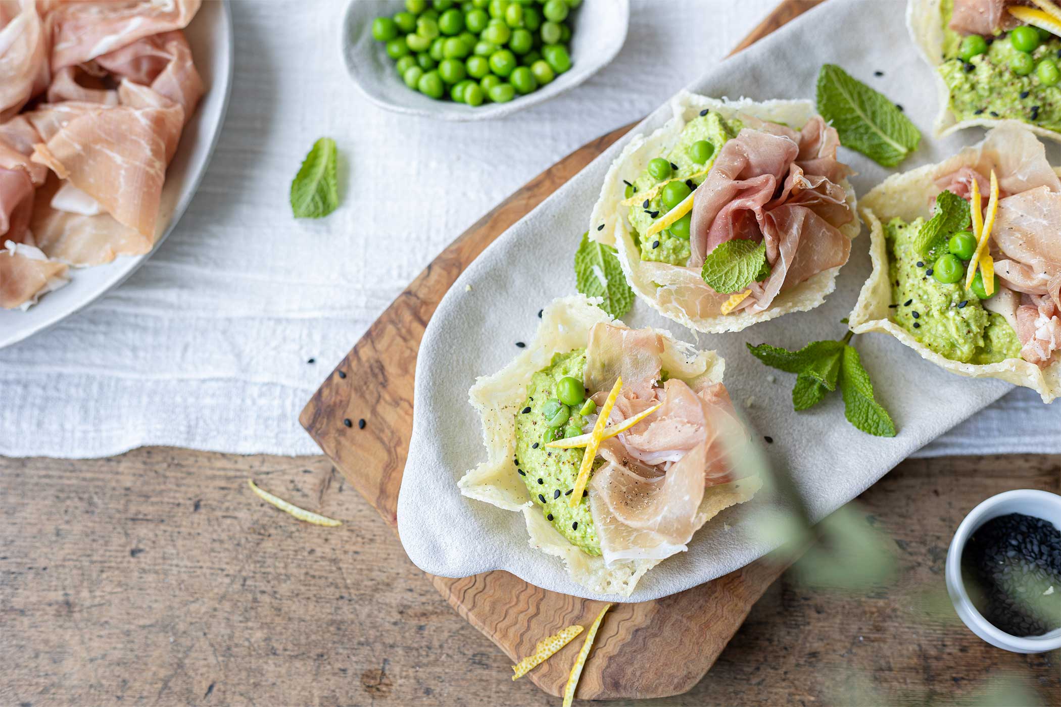 Cestini di parmigiano con Prosciutto di San Daniele e hummus di piselli alla menta