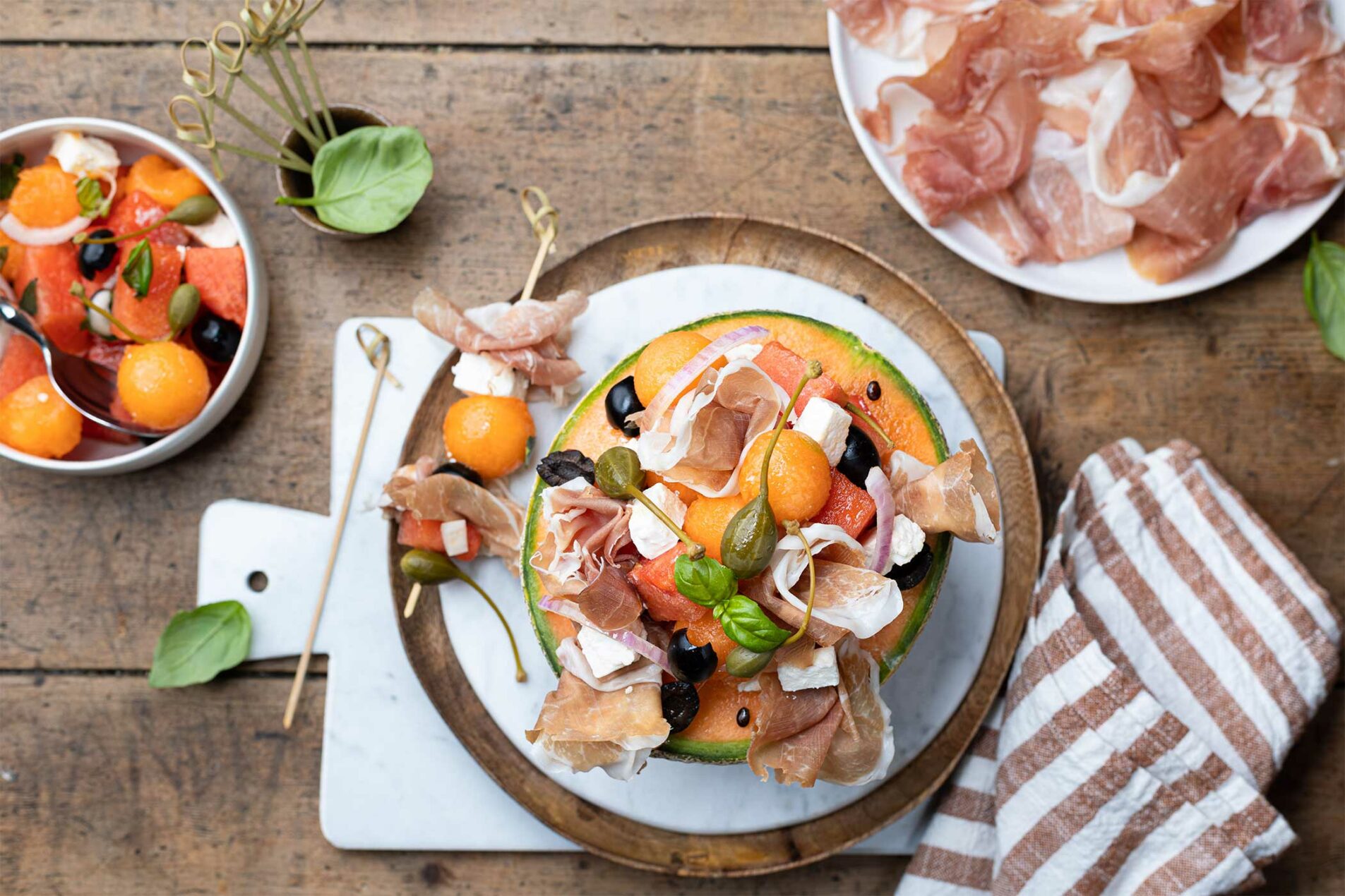 Gefüllte Melone mit Prosciutto di San Daniele, Wassermelone, Fetakäse und schwarze Oliven