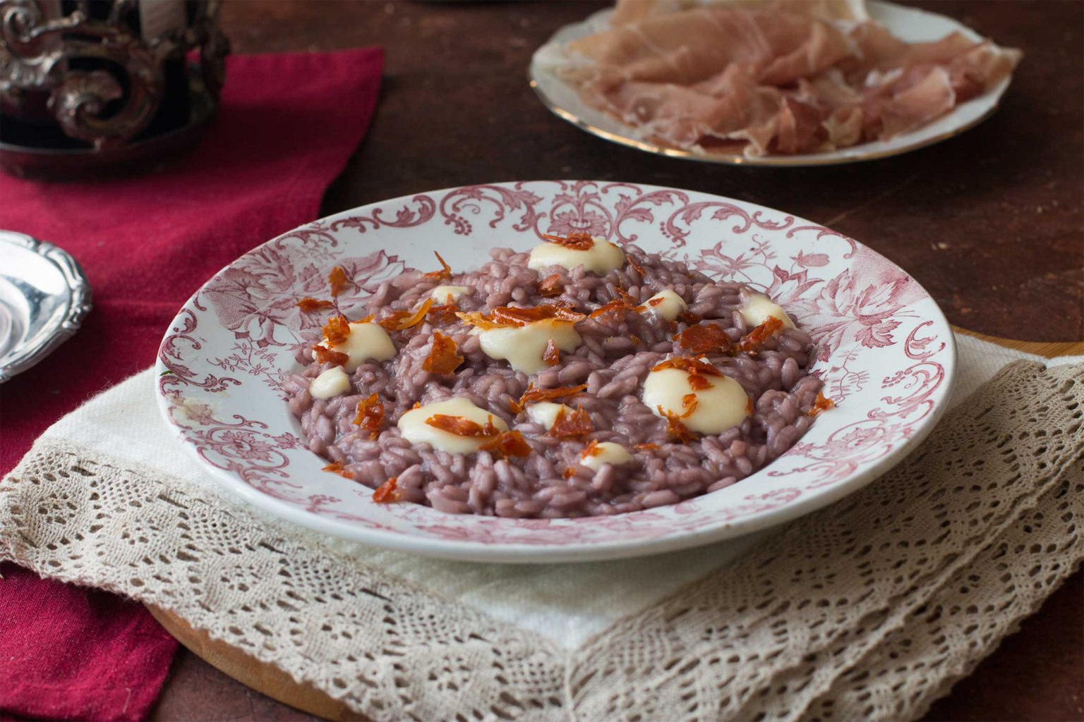 Risotto al vino rosso con fonduta di parmigiano e San Daniele croccante