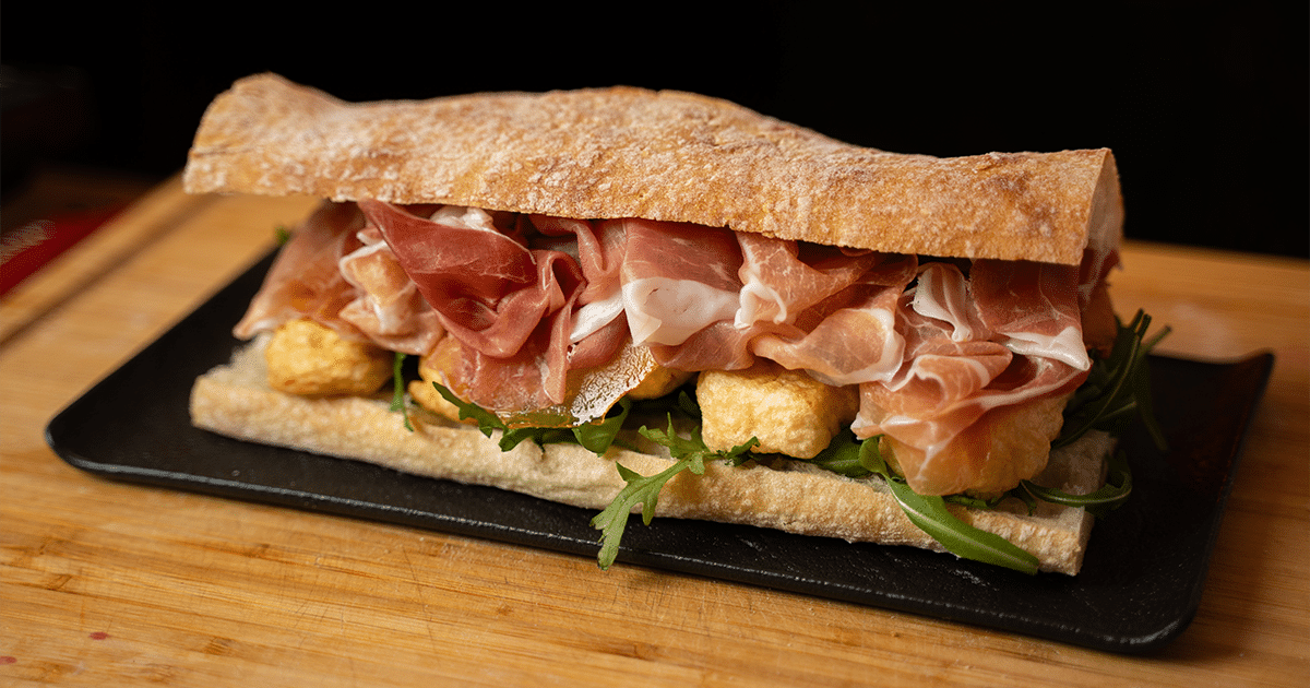 Sandwich mit karamellisierten Birnen, gebackenem Brie, Rucola und San ...