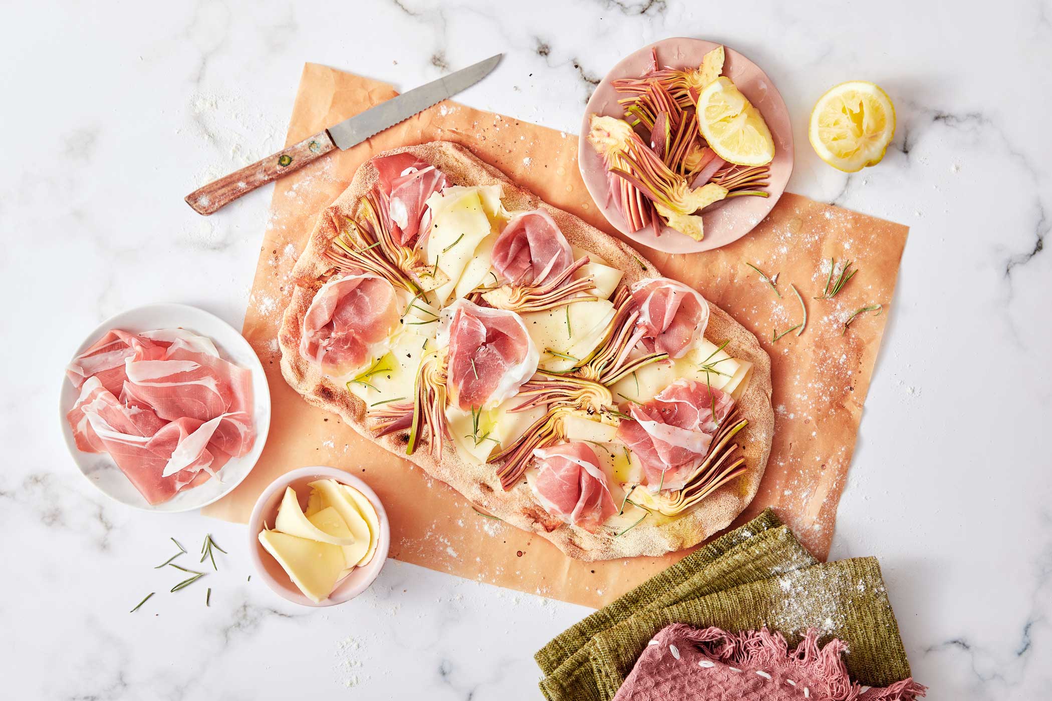 Pinsa con Prosciutto di San Daniele, scamorza dolce e carpaccio di carciofi