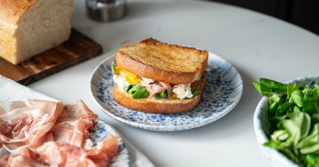 Ricetta estiva del toast con Prosciutto di San Daniele, valeriana, formaggio spalmabile e carpaccio di mango marinato al limone