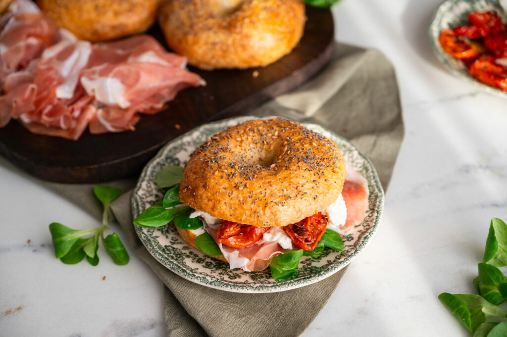 Ricetta per preaparare dei bagel con Prosciutto di San Daniele, mozzarella di bufala, pomodorini confit e zucchine alla scapece