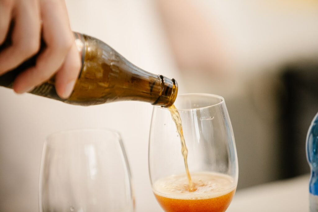 primo piano su persona che versa la birra in un calice