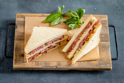 Sandwich con hummus di ceci e basilico, pomodori secchi e Prosciutto di San Daniele