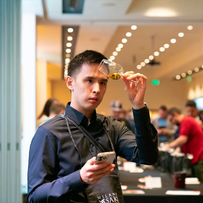 persona che osserva un calice di sakè alla sakè Milano Experience