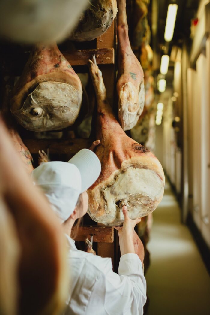 prosciuttificio a San Daniele con operatrice intenta ad analizzare una coscia di Prosciutto stagionata