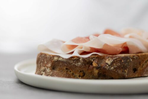 Primo piano di fette di Prosciutto di San Daniele DOP con grasso bianco su pane