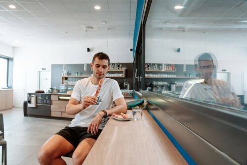 Giovane sportivo mangia Prosciutto di San Daniele come spuntino post allenamento in un padel club