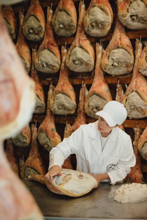 Mastra prosciuttaia applica la sugna sulla coscia di Prosciutto di San Daniele DOP durante la stagionatura