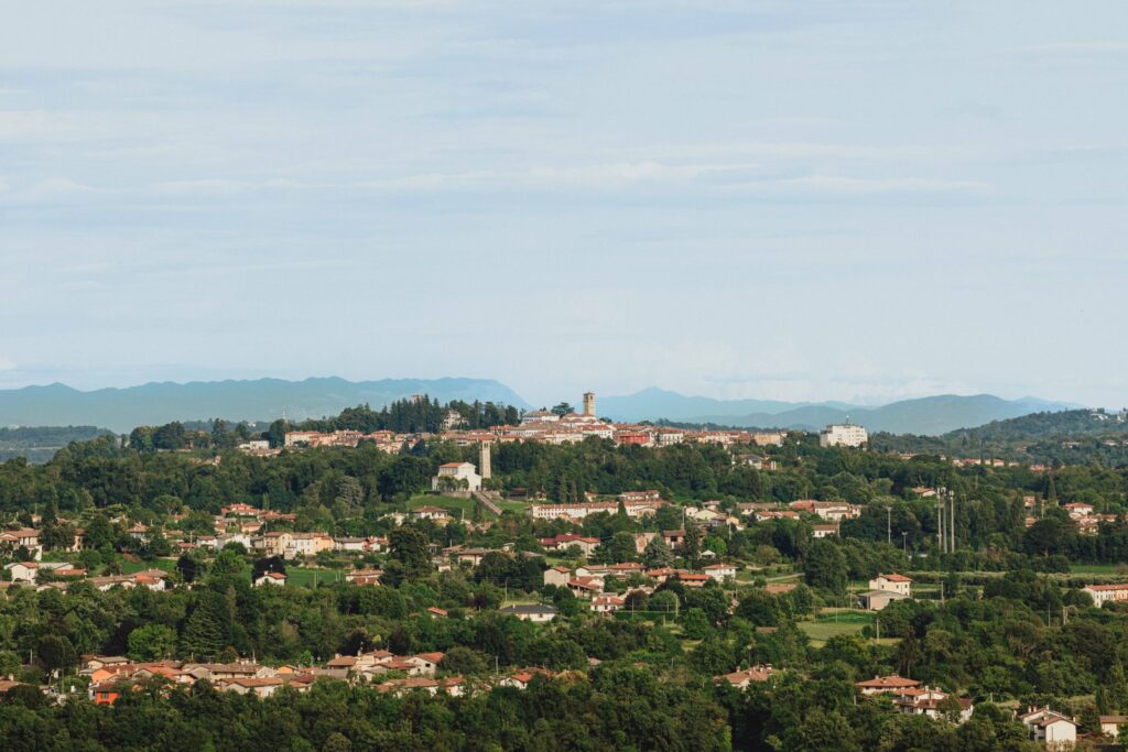 Vista panoramica di cosa visitare a San Daniele del Friuli: il borgo sul Colle Massimo con il campanile del Duomo e le Prealpi sullo sfondo