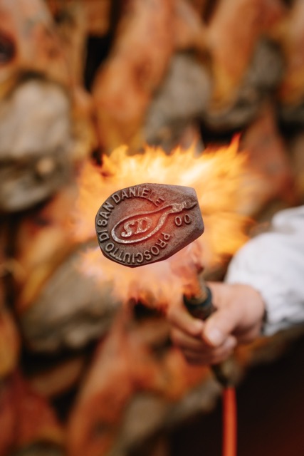 Marchio a fuoco con logo del Consorzio impresso sui prosciutti di San Daniele DOP a fine stagionatura
