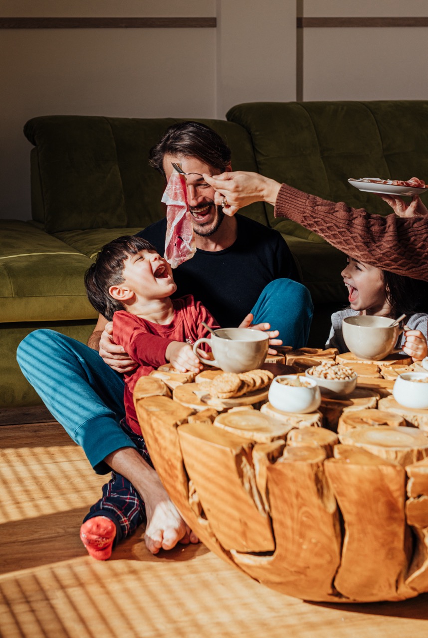 Famiglia con papà e bambini gustano il Prosciutto di San Daniele DOP insieme, spuntino sano e condiviso