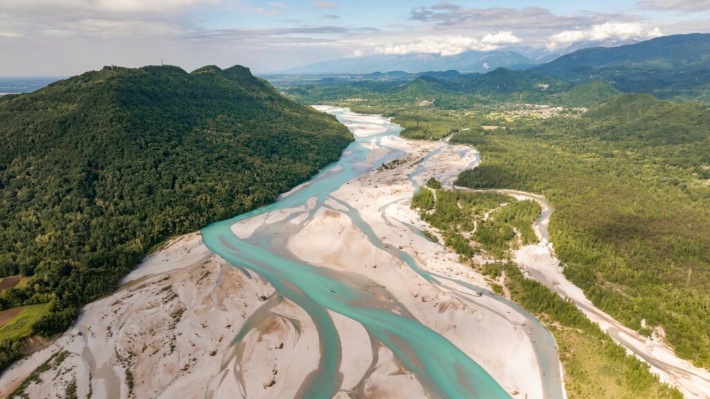 Veduta aerea del Tagliamento tra i boschi del Friuli, ambiente alla base della filiera sostenibile del Prosciutto di San Daniele
